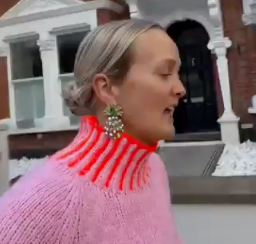 Woman in pink sweater walking and talking